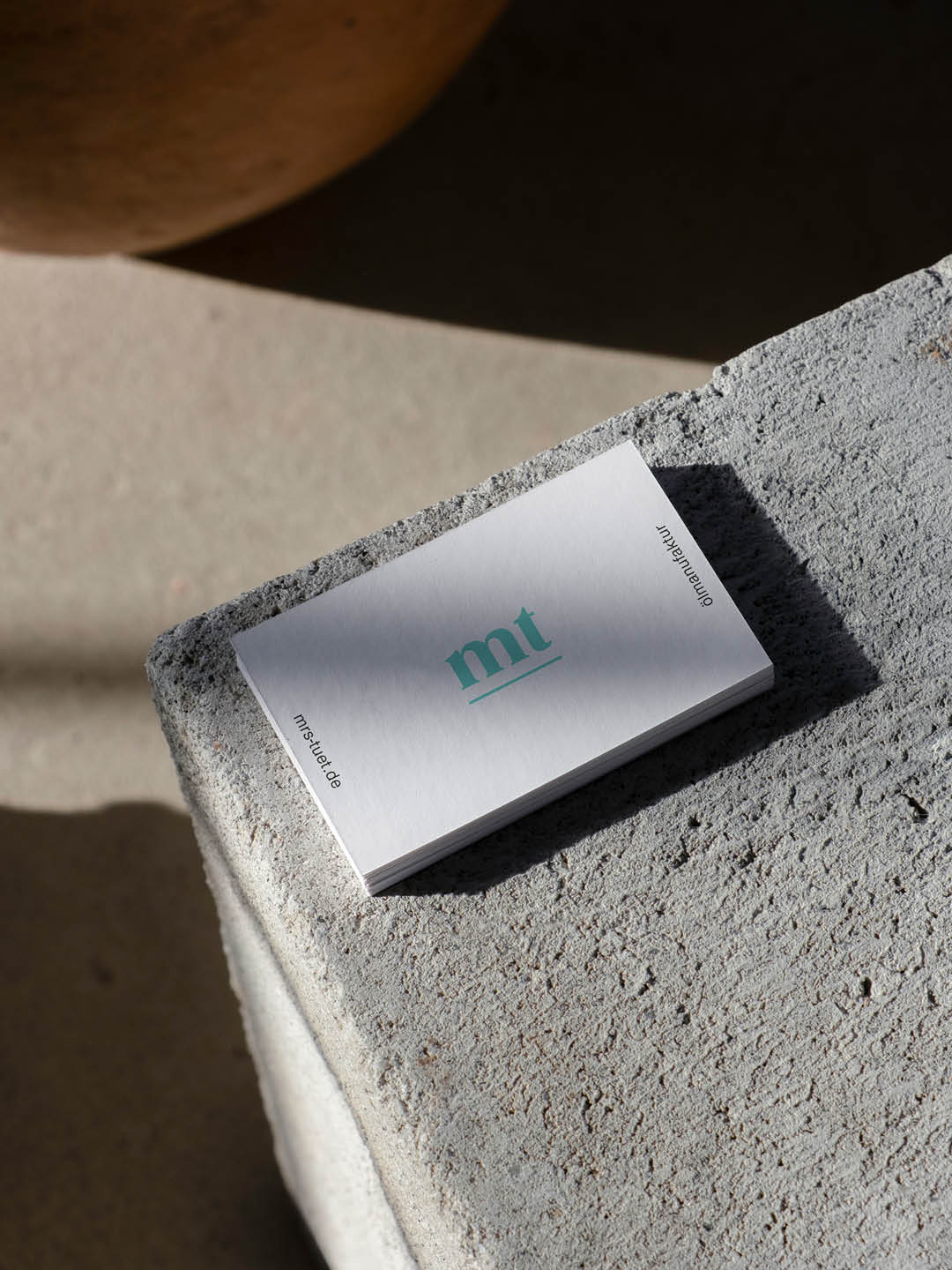 Gestaltete Visitenkarten der Ölmanufaktur Mrs. Tüt auf Steinuntergrund als Teil der Markenentwicklung