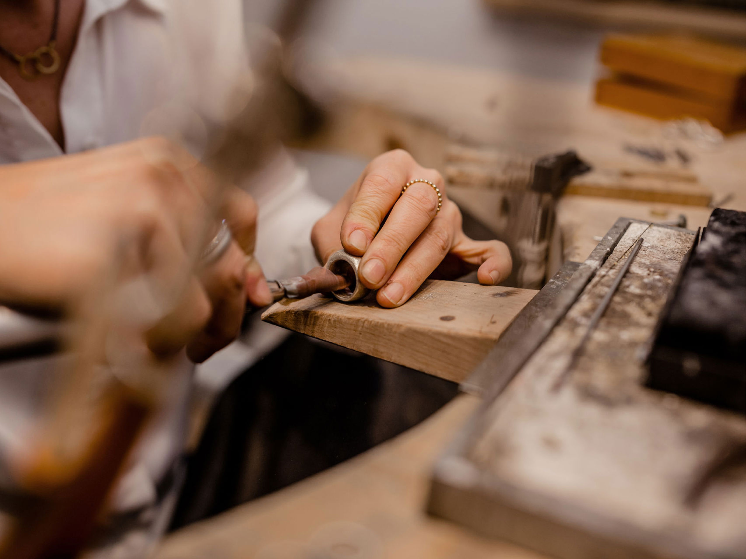 Detailaufnahme Sandra Heiß in der Glücksschmiede Meisterwerkstatt beim Bearbeiten eines Schmuckstücks am Werktisch