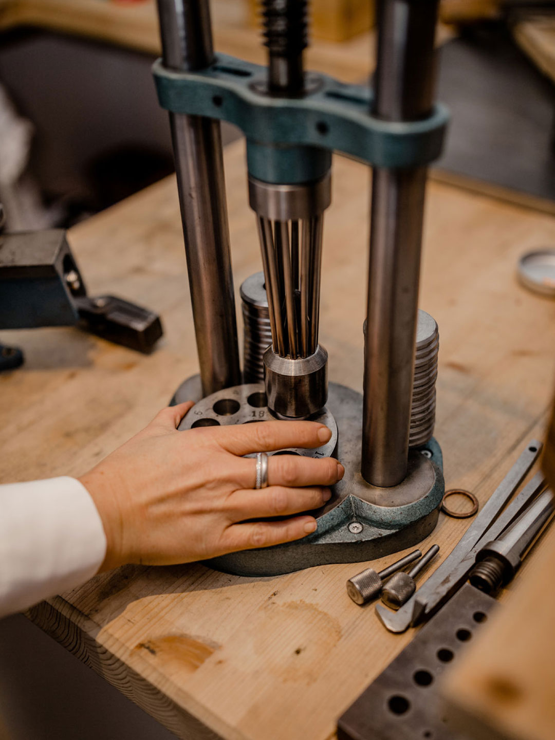 Handarbeit an der Werkbank der Glücksschmiede Meisterwerkstatt – Sandra Heiß arbeitet mit Werkzeugen an einem Ring