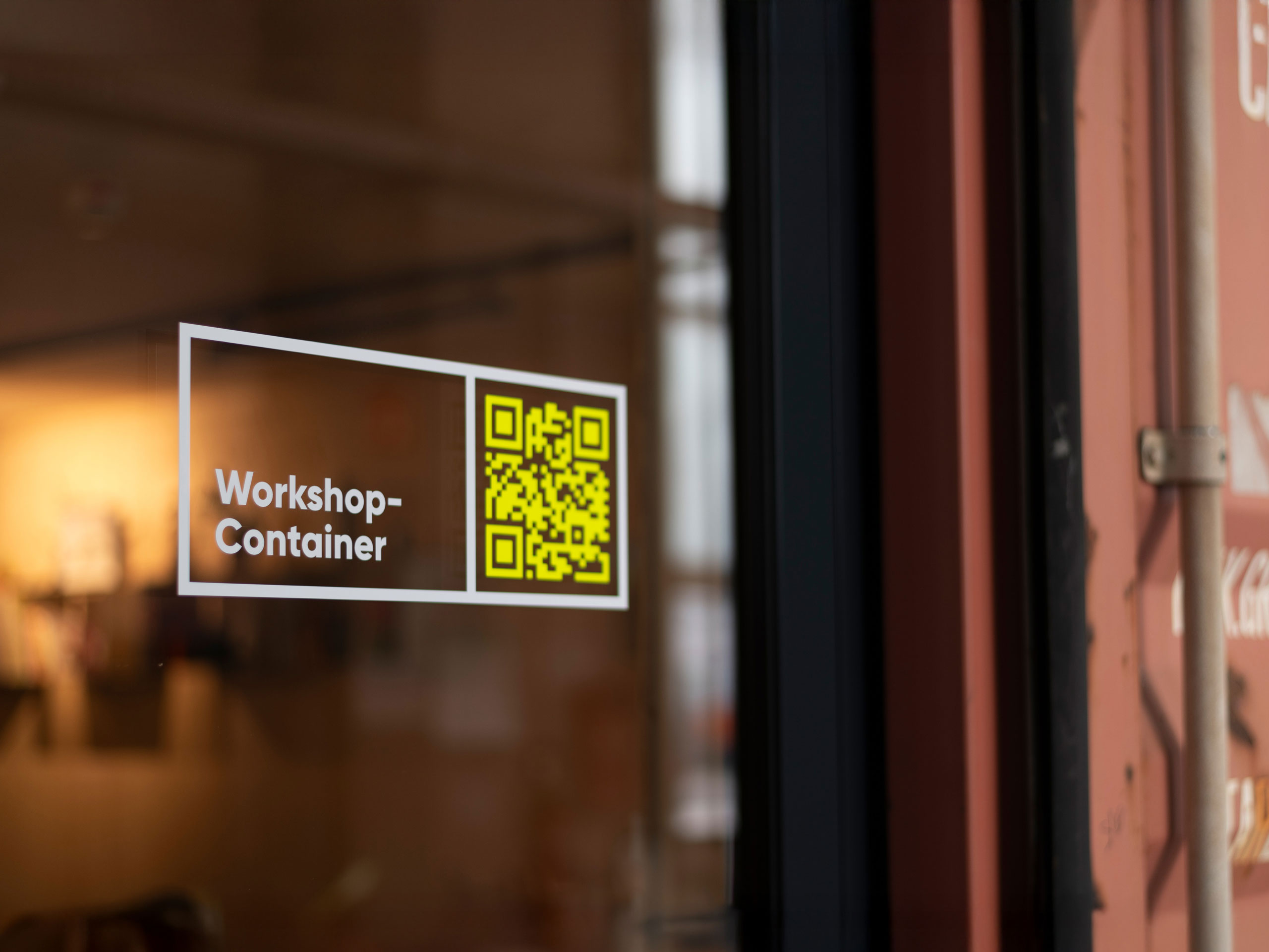 Leitsystem von Hallig Hanken: Türbeschriftung mit QR-Code für den Workshop-Container