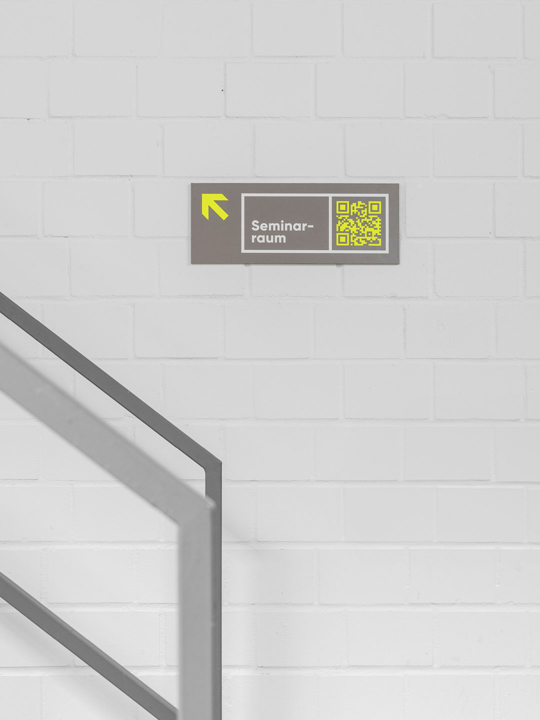 Leitsystem von Hallig Hanken: Wandbeschilderung zum Seminarraum mit Pfeil und QR-Code