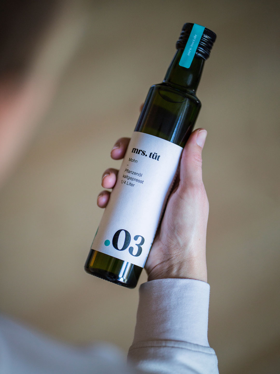 Jemand hält eine Flasche Öl von Mrs. Tüt in der Hand