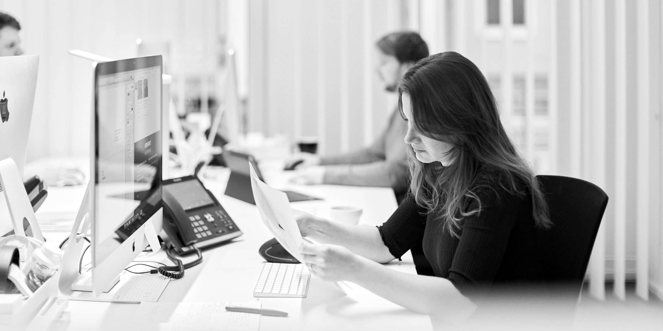 Mitarbeiterin im Büro von Smyk Fischer Architekten bei der Arbeit am Schreibtisch