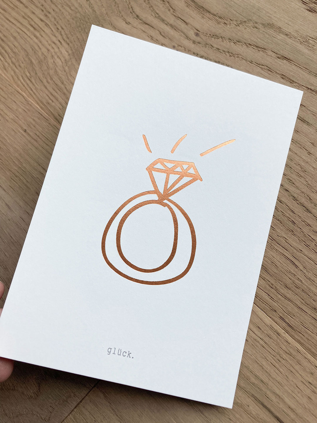 Karte mit goldgeprägter Ringillustration für die Glücksschmiede – Redesign